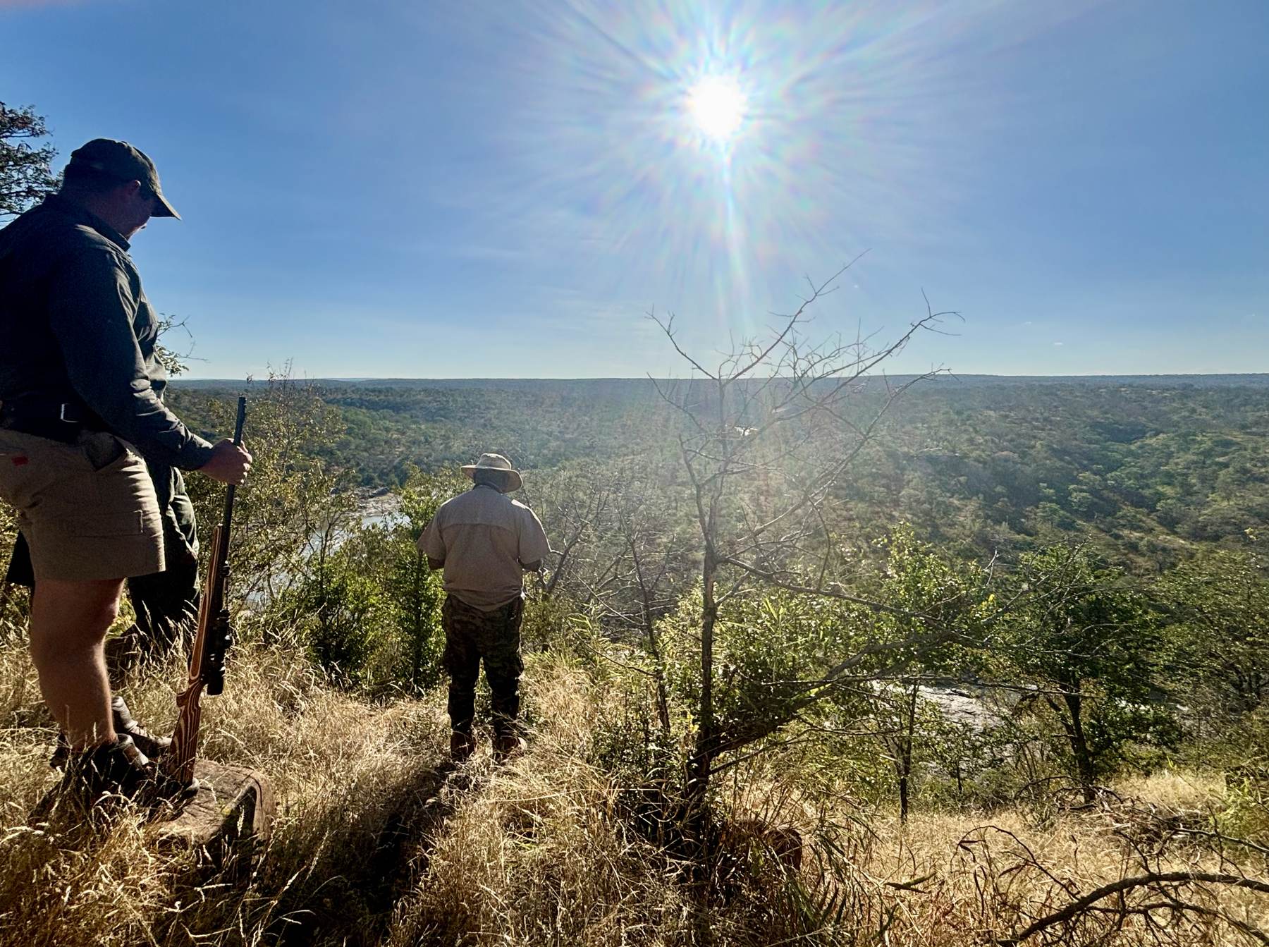 Two hunters working down a wooded hillside in the Zimbabwe hunting area