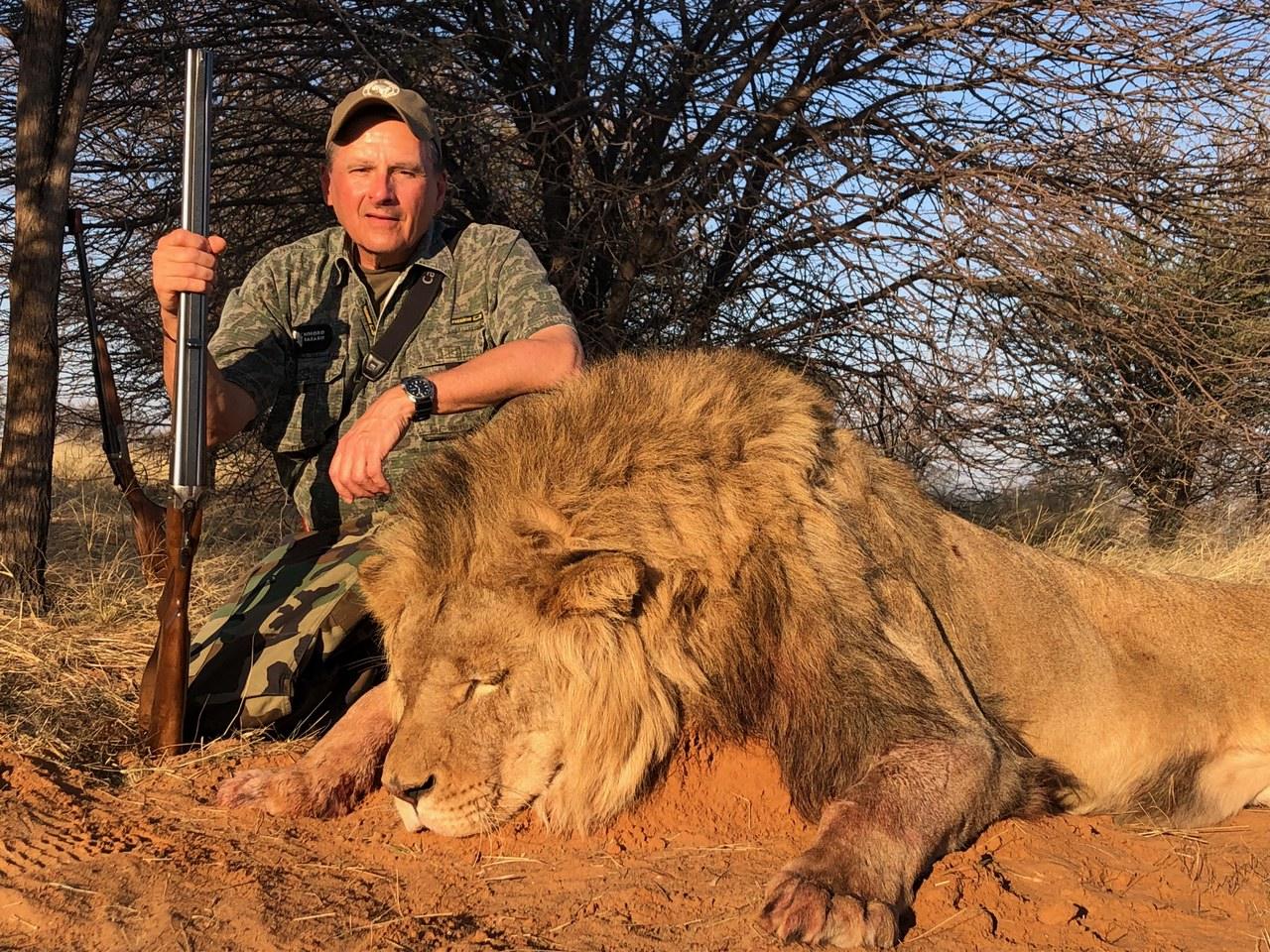 Hunting client and professional hunter with a mature full-maned male lion taken in Zimbabwe