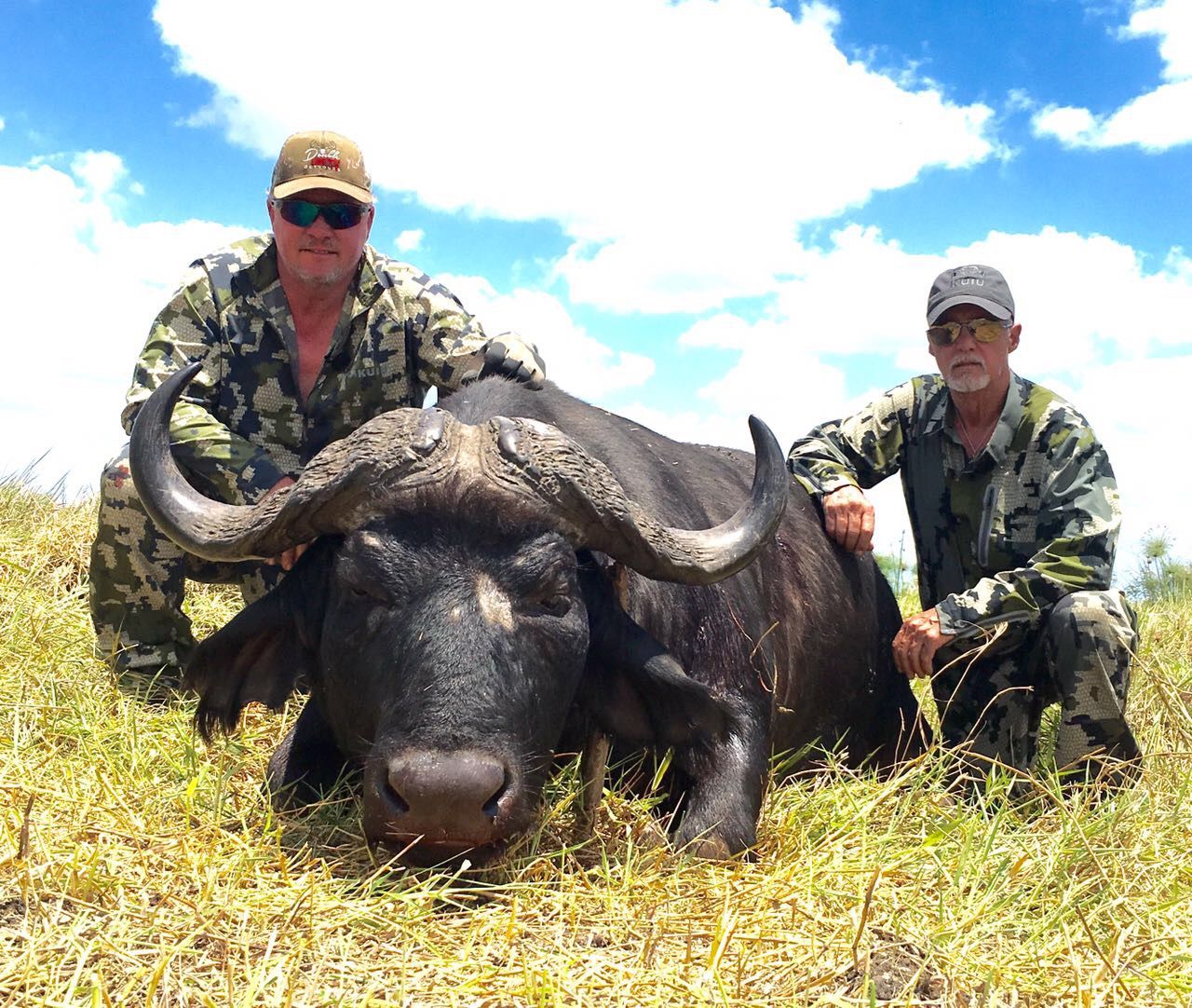 Hunting client and professional hunter with a Cape buffalo bull, Zambezi Delta, Mozambique