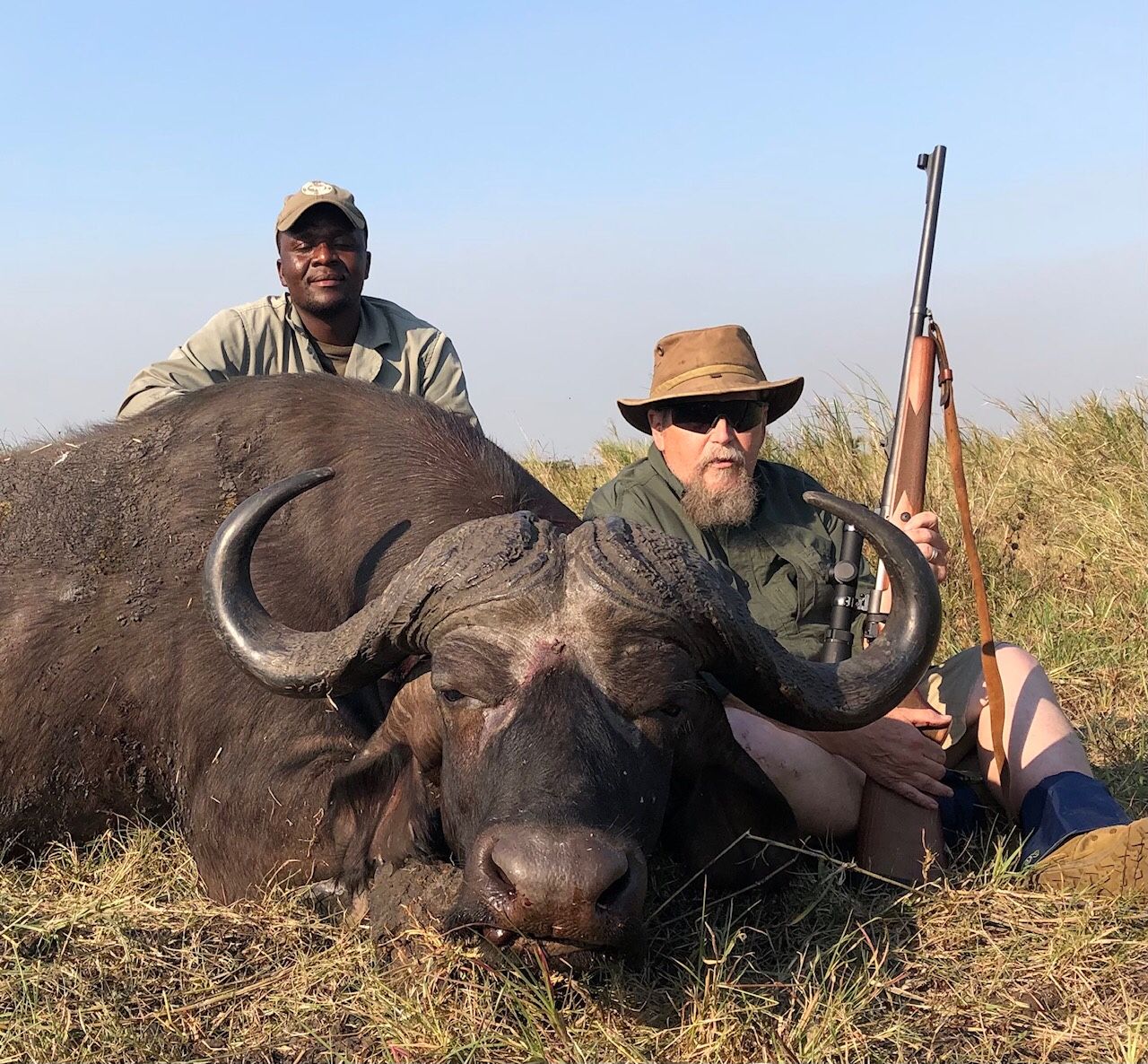 Hunting client and tracker with a Cape buffalo bull, Zambezi Delta, Mozambique