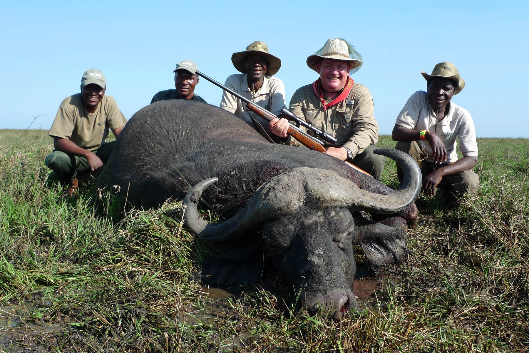Hunting client with the tracking team and a Cape buffalo bull, Zambezi Delta, Mozambique