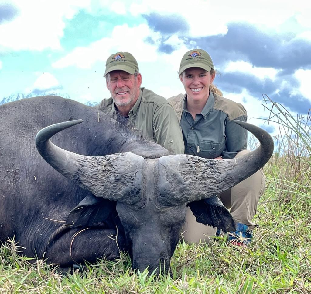 Two hunting clients with a wide-horned Cape buffalo bull, Zambezi Delta, Mozambique