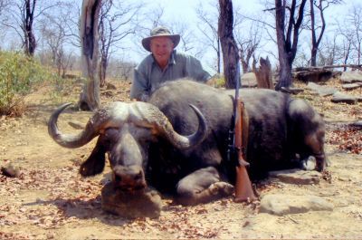 Hunter with a Cape buffalo bull taken on rocky ground in Zimbabwe