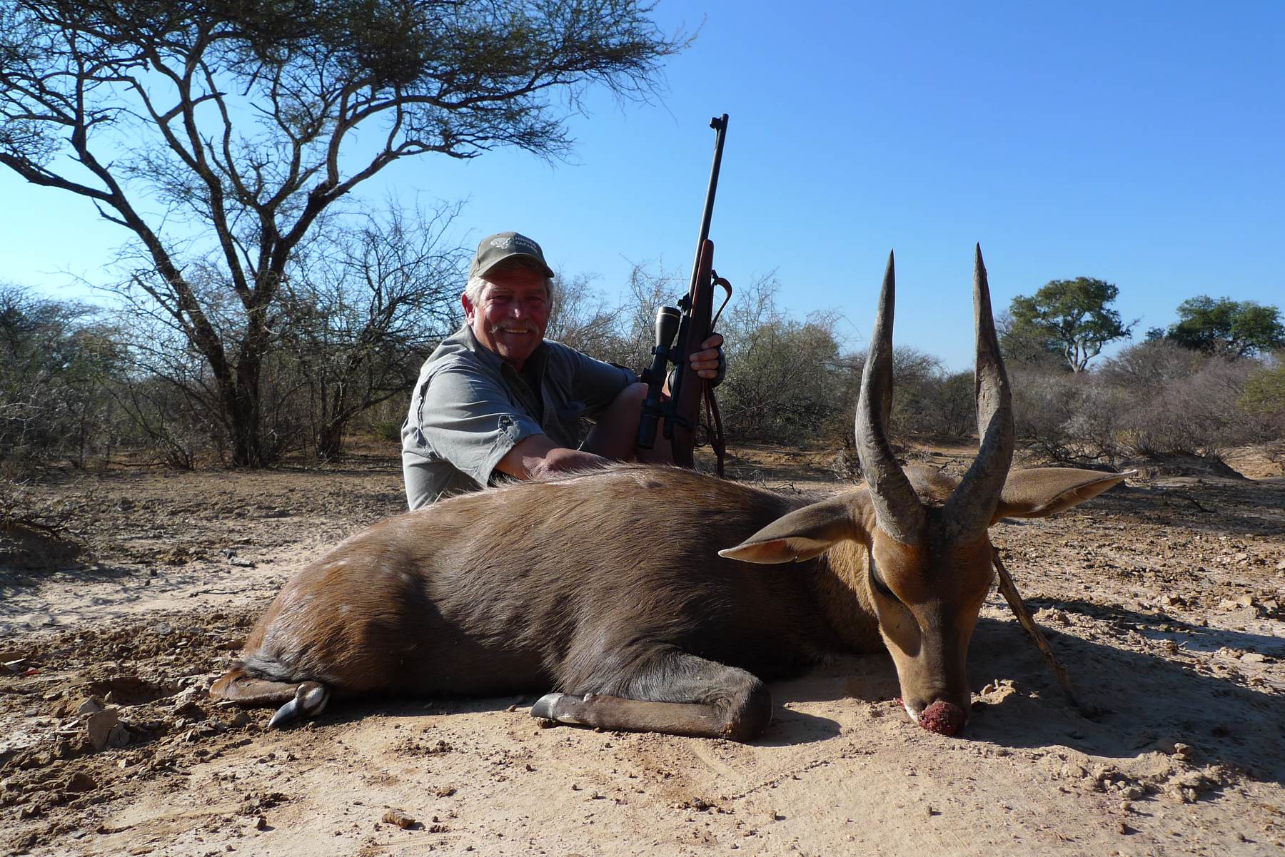 Hunter with a bushbuck ram taken in riverine bush, Limpopo, South Africa