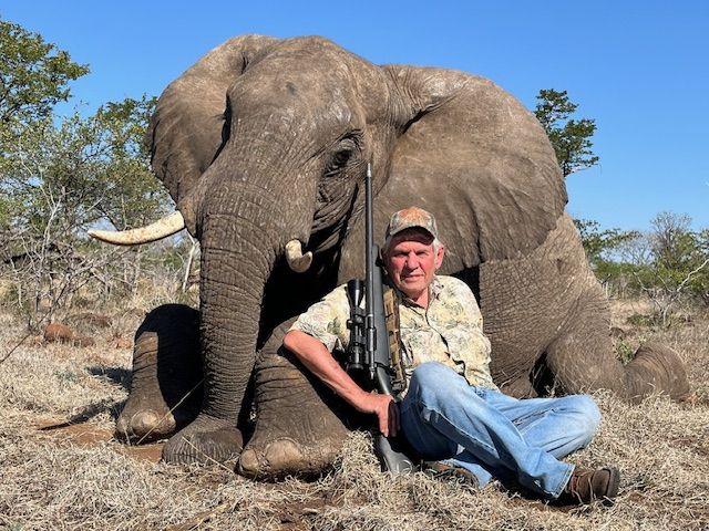 Hunting client seated beside an elephant bull taken in Zimbabwe