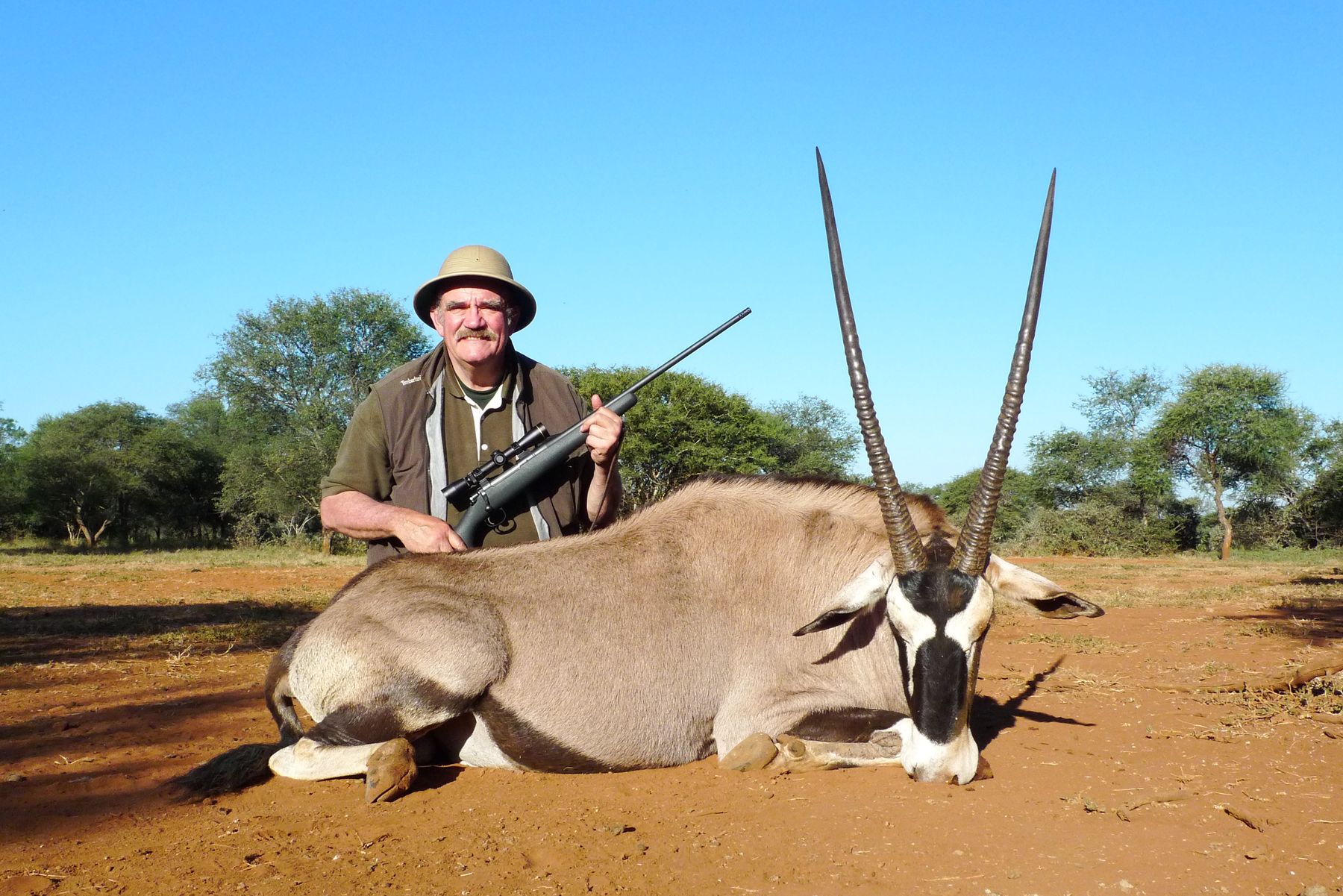 Hunting client with a gemsbok bull taken on red sand, South Africa