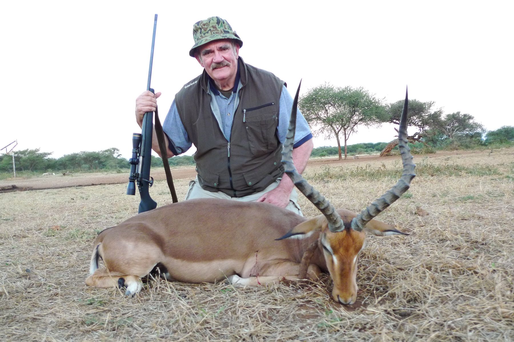Hunting client with an impala ram taken in open bushveld, Limpopo, South Africa