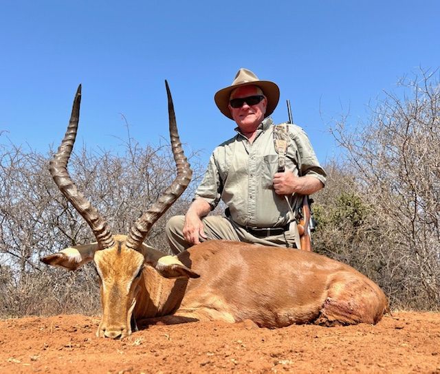 Hunter with an impala ram taken on red Limpopo soil, South Africa