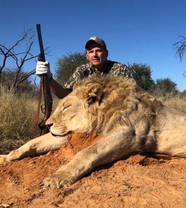 Hunter with a heavy-maned mature male lion