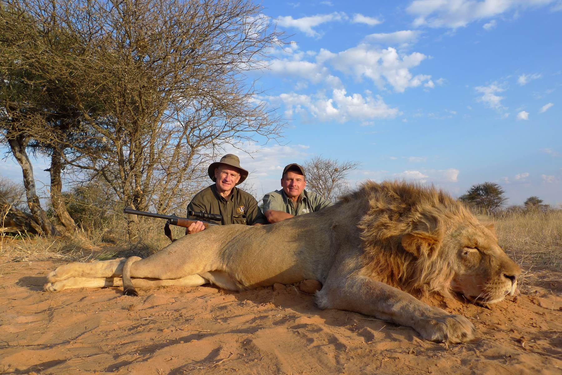 Hunting client and professional hunter with a mature male lion