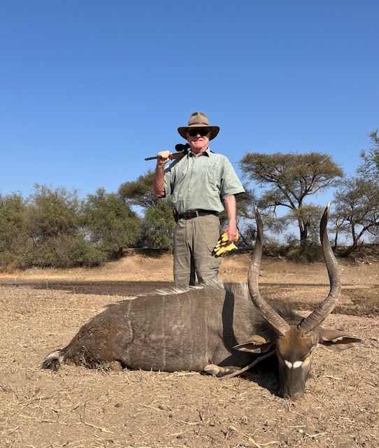 Hunting client with a nyala bull taken on dry ground, Limpopo, South Africa