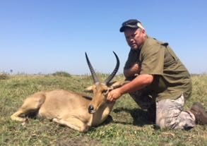 Hunter with a reedbuck ram taken on the floodplain, Zambezi Delta, Mozambique
