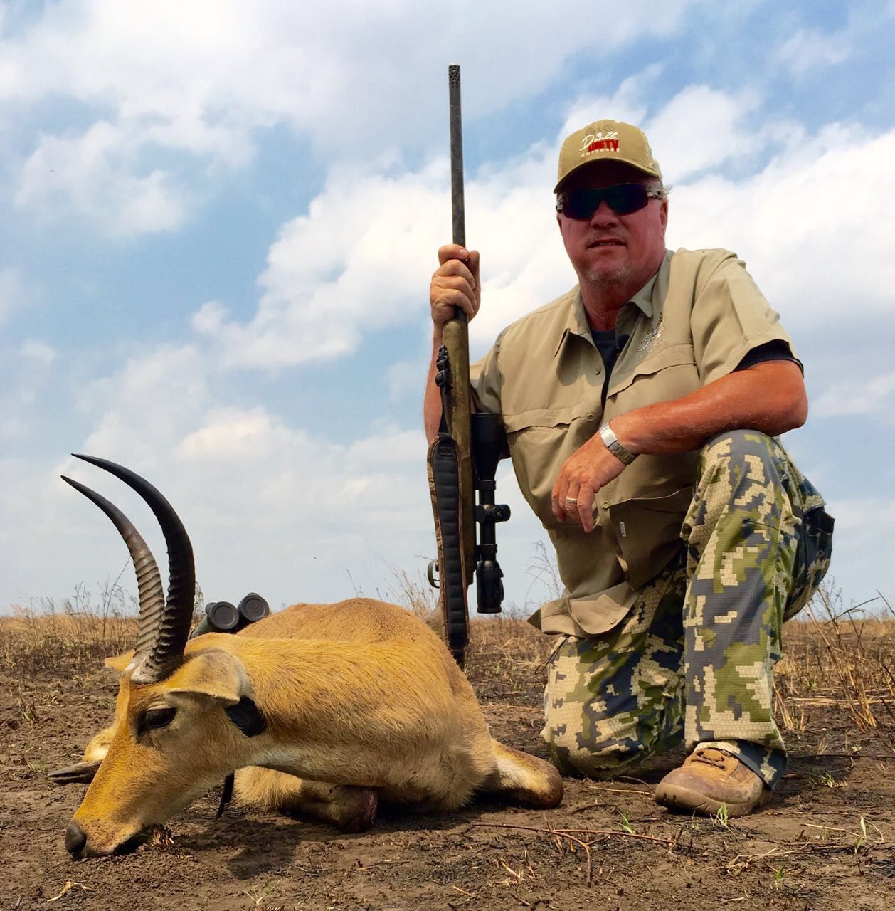 Hunting client with his rifle beside a reedbuck ram, Zambezi Delta, Mozambique