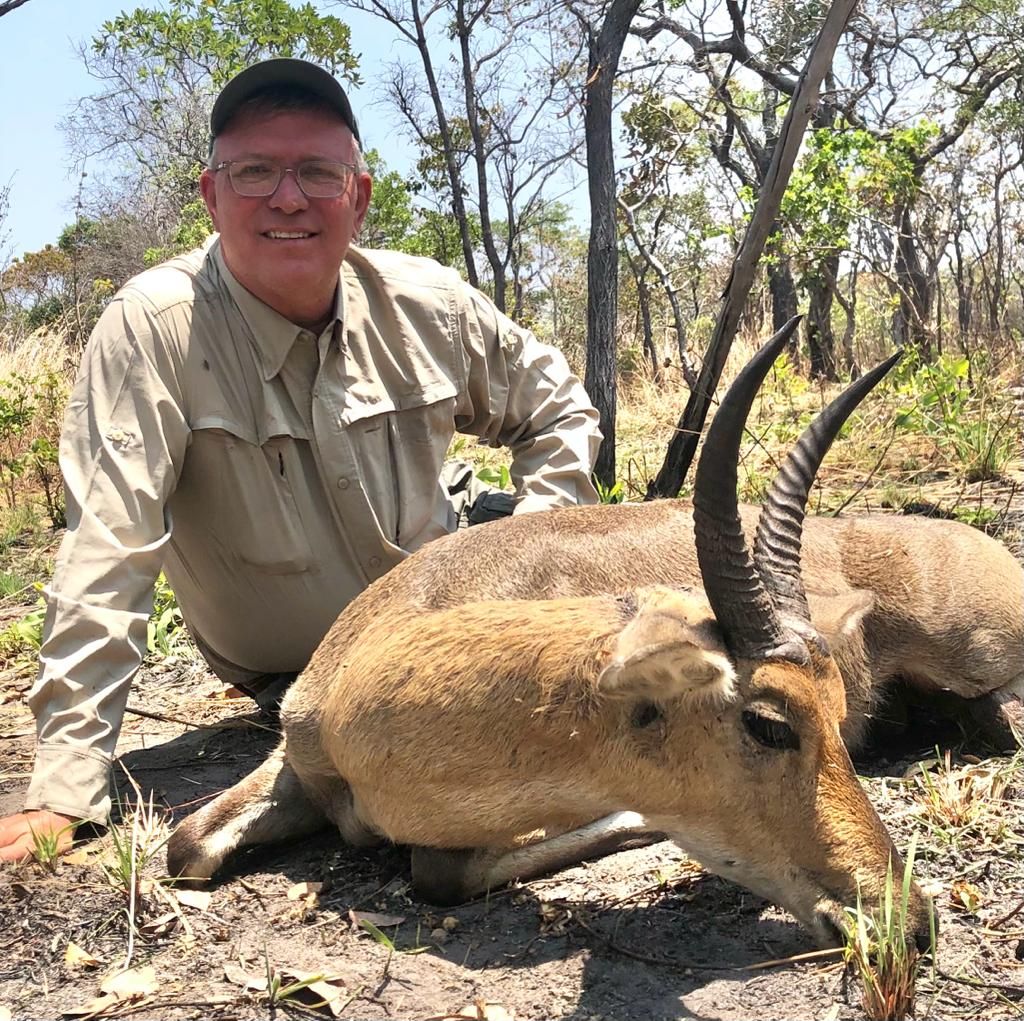 Hunting client with a reedbuck ram taken in open woodland, Zambezi Delta, Mozambique