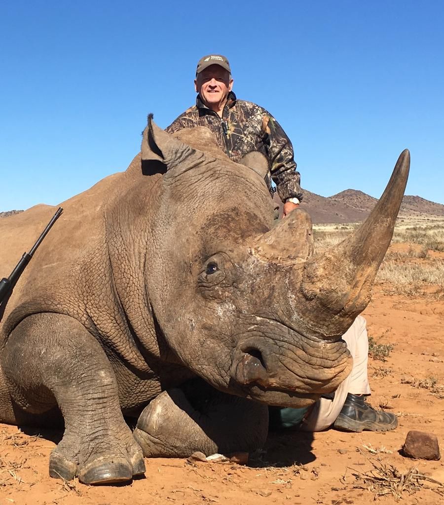 White rhino bull taken on red sand with the hunting client, South Africa