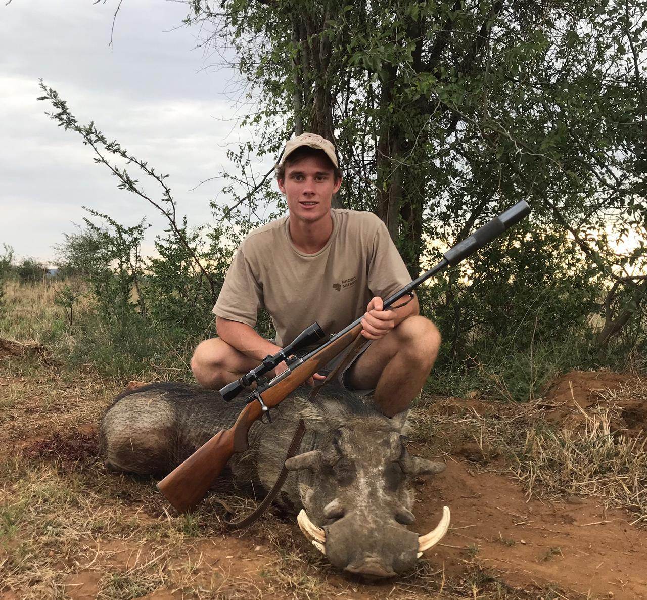 Young hunting client with a warthog boar taken in Limpopo, South Africa