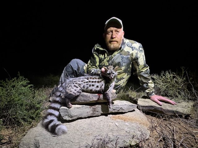 Hunter with a large-spotted genet taken on a night hunt in Limpopo, South Africa