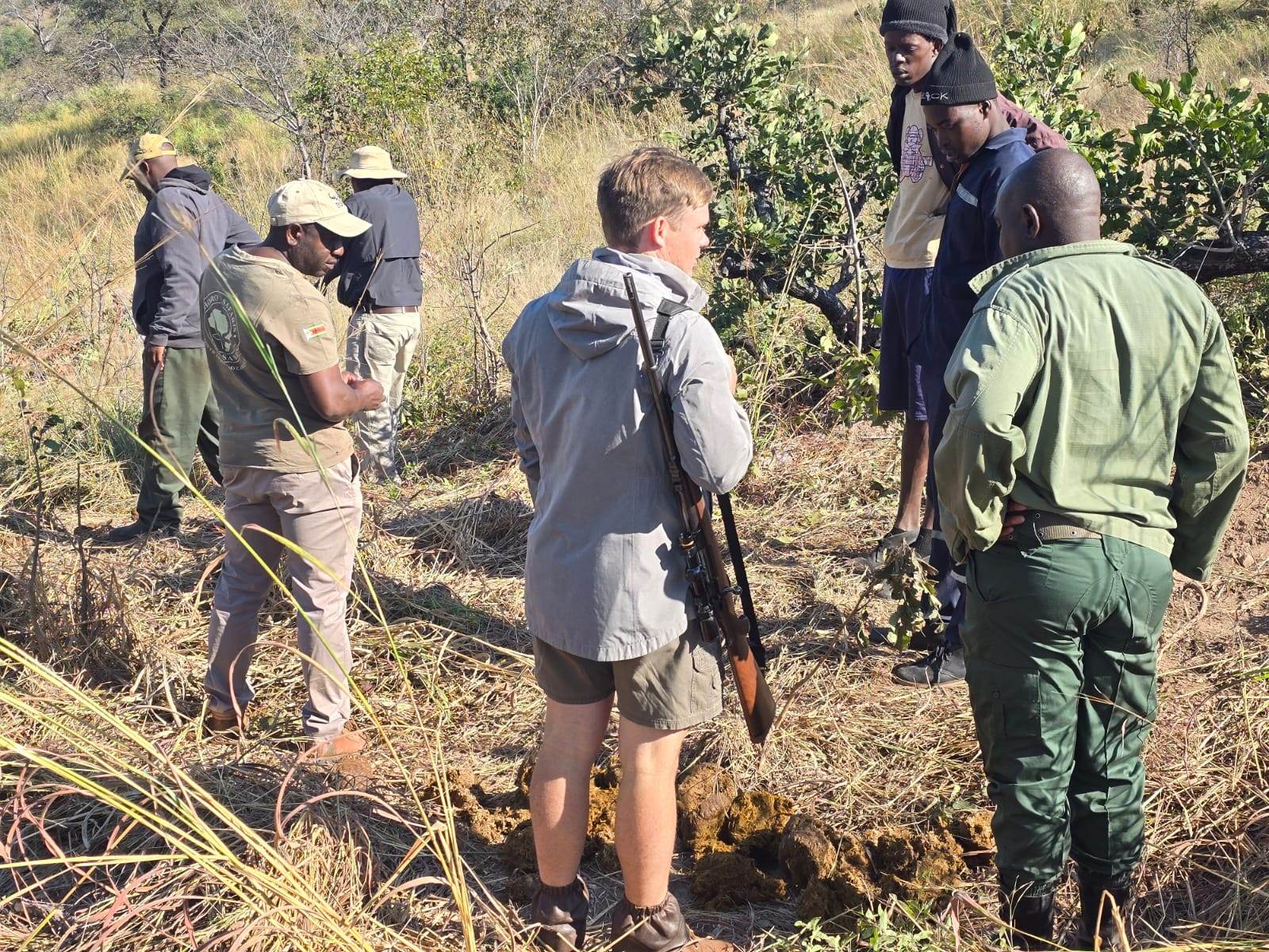 Hunting team gathered in long grass at the end of a stalk in Zimbabwe with Nhoro Safaris